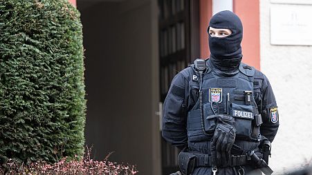 FILE - Police officers stand by a searched property in Frankfurt during a raid against so-called 'Reich citizens' in Frankfurt, Germany, on Dec. 7, 2022.