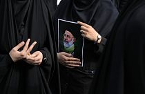 İranlı bir kadın Tahran'da Reisi için düzenlenen yas töreni sırasında onun posterini tutuyor