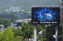 A screen shows an announcement of the AI Seoul Summit in Seoul, South Korea.