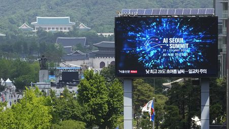 A screen shows an announcement of the AI Seoul Summit in Seoul, South Korea.