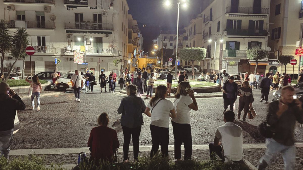 People gather in a street after an earthquake in Campi Flegrei, near Naples, Italy, Monday, May 20, 2024.
