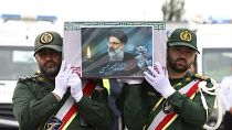 عناصر من الحرس الثوري يحملون نعش الرئيس إبراهيم رئيسي المغطى بالعلم خلال مراسم تشييعه في مدينة تبريز، إيران.