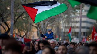 صبي يلوح بالعلم الفلسطيني خلال مسيرة الفلسطينيين في برشلونة، إسبانيا