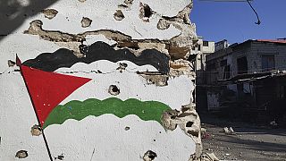 A Palestinian flag painted on a wall full of bullet holes is seen in the Palestinian refugee camp of Ein el-Hilweh near the southern port city of Sidon, Lebanon, 2023. 