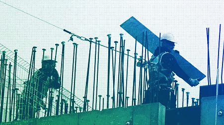 Builders are silhouetted as they work at a construction site in London, September 2018