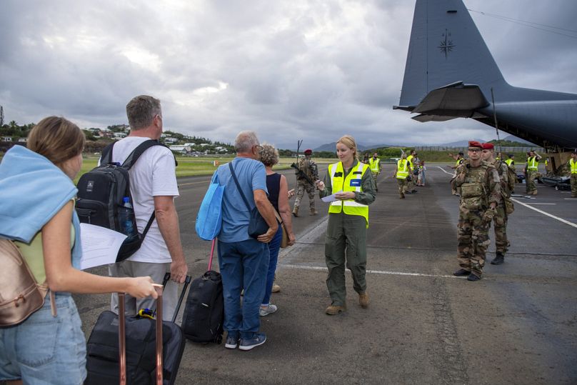Auf diesem von den neuseeländischen Streitkräften veröffentlichten Foto borden neuseeländische Touristen am Dienstag, den 21. Mai 2024, am Magenta Airport in Noumea.
