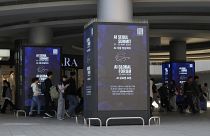 People pass by screens announcing the upcoming AI Seoul Summit in Seoul, South Korea.