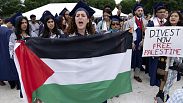 طلاب جامعة جورج واشنطن يحملون العلم الفلسطيني خلال احتجاج مؤيد للفلسطينيين في حفل التخرج في واشنطن، 19 مايو، 2024.