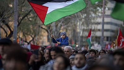 FILE - A boy waves a Palestinian flag as demonstrators march during a protest in support of Palestinians in Barcelona, Spain, on Jan. 20, 2024.