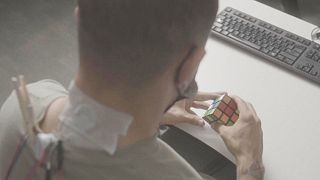 Patient on trial manipulating a Rubik's cube during stimulation