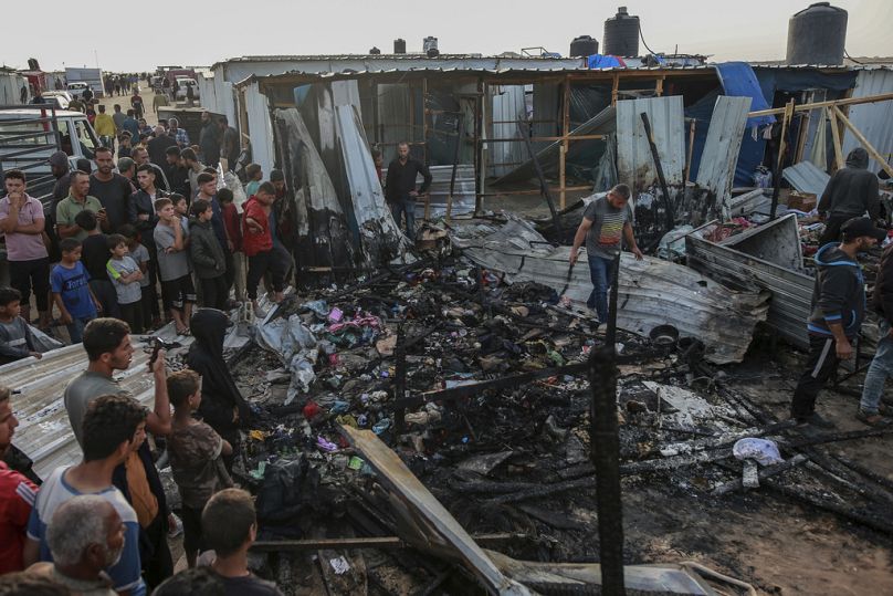 Palestinos observan la destrucción tras un ataque israelí donde se alojaban personas desplazadas en Rafah, Franja de Gaza, lunes 27 de mayo de 2024.