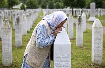 Sefika Mustafic kisses the grave of her son, victim of the Srebrenica genocide, at the Memorial Center in Potocari, Bosnia, Wednesday, May 22, 2024. 