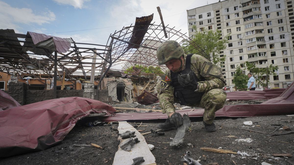 A sapper inspects fragments of a Russian air bomb that hit a living area injuring ten in Kharkiv, Ukraine, Wednesday, May 22, 2024.