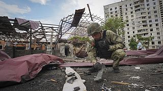 Un sapeur inspecte les fragments d'une bombe aérienne russe qui a touché une zone d'habitation et blessé dix personnes à Kharkiv, en Ukraine, le mercredi 22 mai 2024.