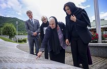 Nusrat Ghani walks with  Munira Subasic next to the momument with the names of Srebrenica genocide victims in Potocari, Bosnia, Wednesday, May 22, 2024.