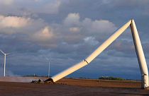 The remains of a tornado-damaged wind turbine touch the ground in a field, Tuesday, May 21, 2024, near Prescott, Iowa. 