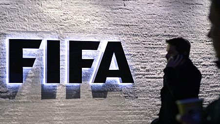 En esta foto del 2 de diciembre de 2015, un hombre frente al logotipo de la sede de la FIFA "Home of FIFA" en Zúrich, Suiza. (Walter Bieri/Keystone vía AP)