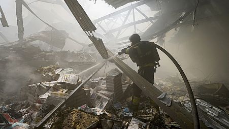 Firefighters put out a fire after a Russian missile hit a large printing house in Kharkiv, Ukraine, Thursday, May 23, 2024.