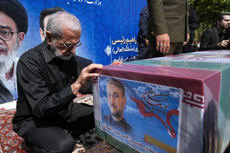 Former Iranian Foreign Minister Kamal Kharrazi pays respect to the flag-draped coffin of the late Foreign Minister Hossein Amirabdollahian.