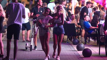 Tourists walk at the resort of Magaluf on the Spanish Balearic island of Mallorca, Spain, Thursday morning, July 16, 2020.