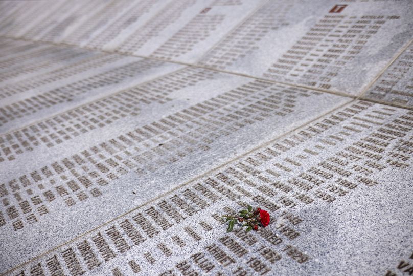 Bosna'nın Potocari kentindeki Anma Merkezi'nde Srebrenitsa soykırımında öldürülenlerin isimlerinin yazılı olduğu anıtın üzerine bırakılan bir gül
