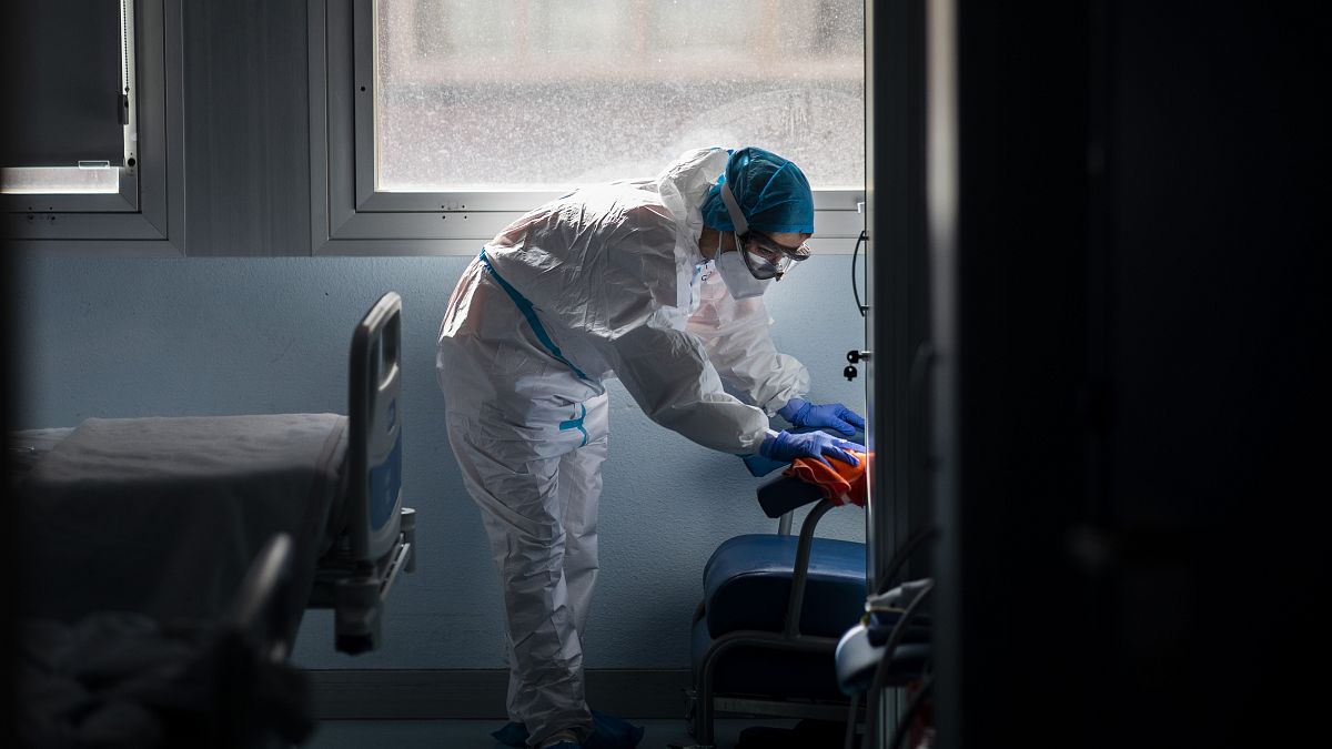 Un trabajador de la limpieza desinfecta una habitación de hospital en una zona de enfermedades infecciosas.