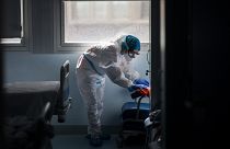 Un trabajador de la limpieza desinfecta una habitación de hospital en una zona de enfermedades infecciosas.