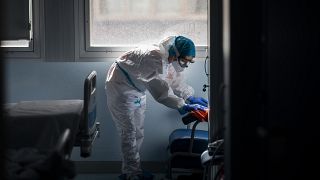 A cleaning worker disinfects a hospital room in a zone for infectious disease.