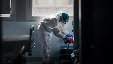 A cleaning worker disinfects a hospital room in a zone for infectious disease.