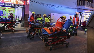 Medics take injured people away from a building that collapsed in Palma de Mallorca, Spain, Thursday May 23, 2024