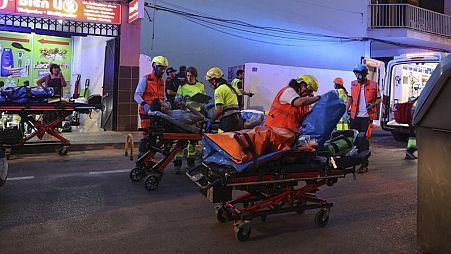Medics take injured people away from a building that collapsed in Palma de Mallorca, Spain, Thursday May 23, 2024