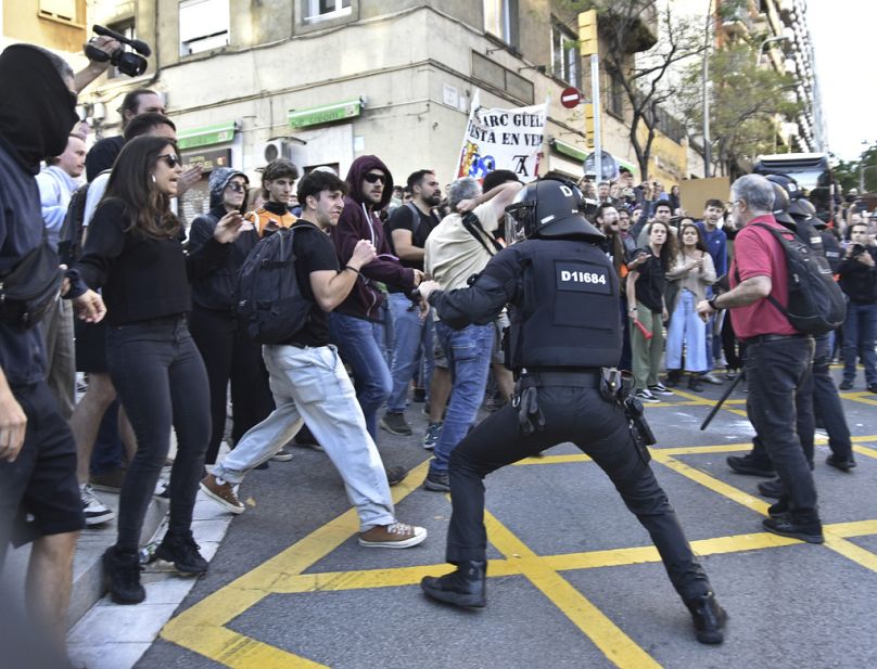 Police and demonstrators clash during a protest outside the Park Guell in Barcelona, Spain, Thursday May 23, 2024.