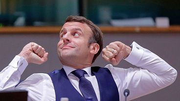 Macron stretches after an all night negotiating session at an EU summit in Brussels, December 2020, where leaders have agreed to cut the bloc's emissions by 55% by 2030. 