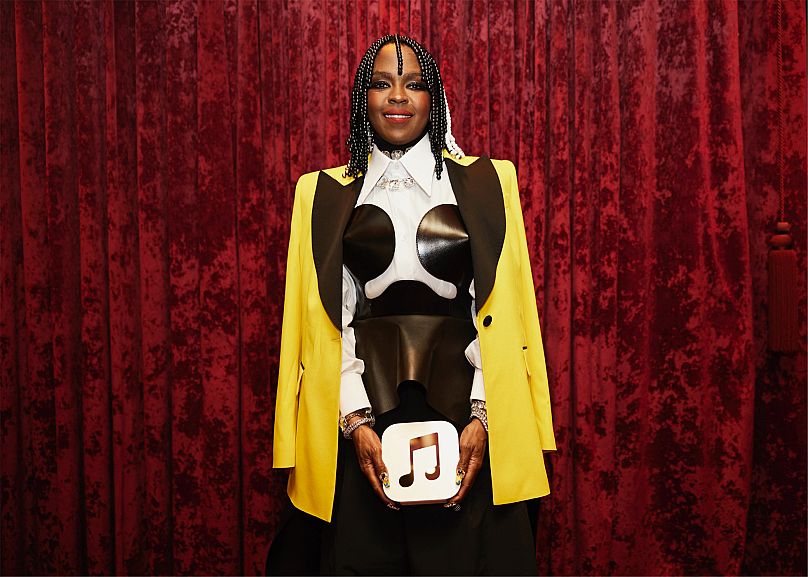 Lauryn Hill poses with her 100 Best Albums award, which is made of blasted anodised aluminium, sourced entirely from recycled Apple products.