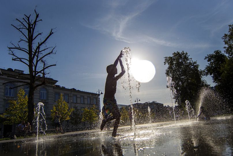 Un garçon se rafraîchit dans une fontaine publique à Vilnius, en Lituanie.