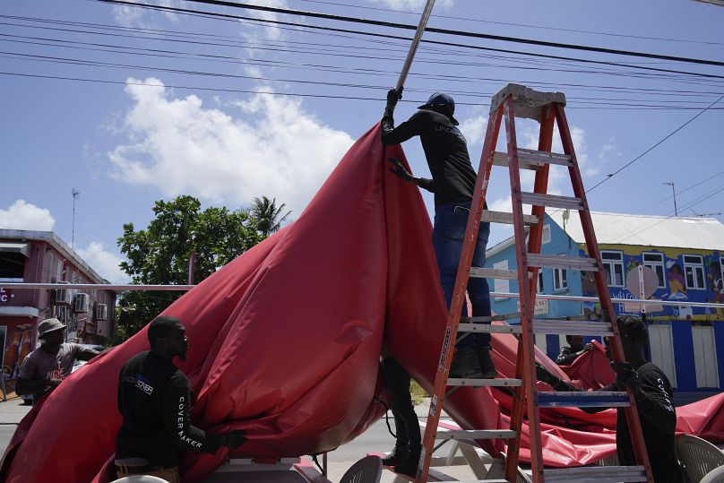 People disassemble a beach bar's awning in preparation for Hurricane Beryl, in Bridgetown, Barbados.