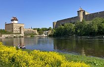Dos hombres pescan cerca del castillo de Narva, en el río del mismo nombre que ejerce de frontera natural entre Estonia y Rusia, el miércoles 24 de mayo de 2023.
