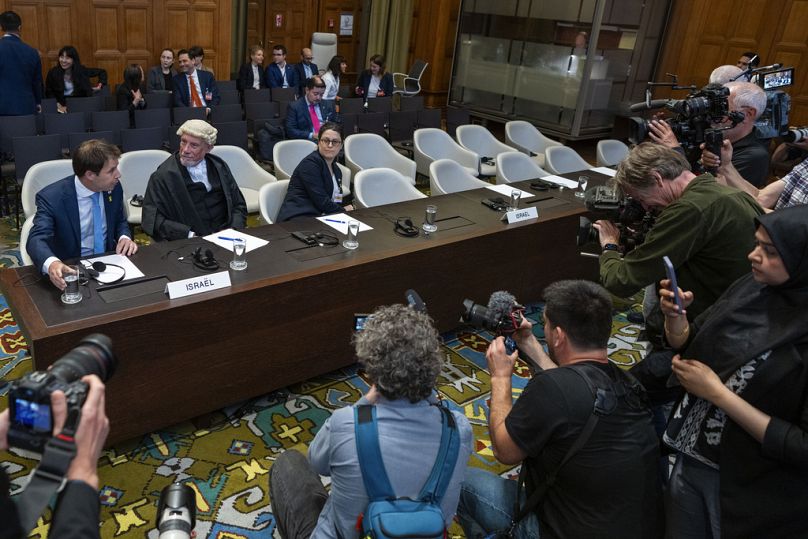 Des journalistes prennent des photos de l'équipe juridique d'Israël à la Cour internationale de justice de La Haye, le 24 mai 2024.