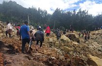 People cross over the landslide area to get to the other side in Yambali village, Papua New Guinea, May 24, 2024
