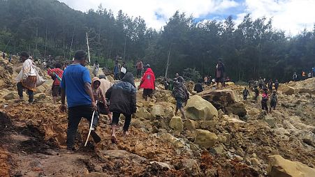 Uma pessoa ferida é transportada numa maca após um deslizamento de terras na aldeia de Yambali, Papua Nova Guiné, 24 de maio de 2024