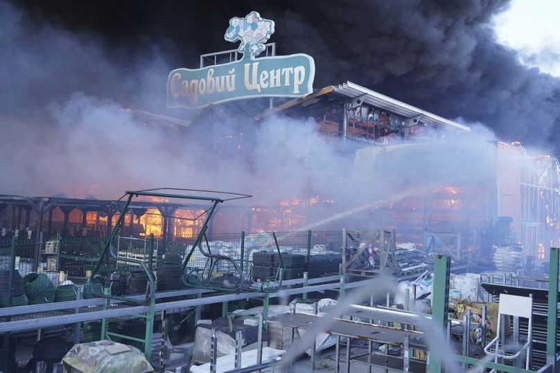 Firefighters put out a fire after two guided bombs hit a large construction supplies store in Kharkiv, Ukraine, Saturday, May 25, 2024. Writing reads "Garden Center".