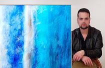 Artist Giovanni Guida with the work "Vital breath, in the blue of the sky"