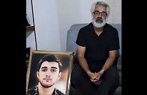 ماشالله کرمی در کنار عکس پسرش محمدمهدی کرمی