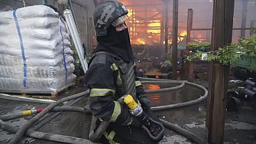 Bombero apagando fuego después de que un misil guiado alcanzase un almacén de suministros en Járkov
