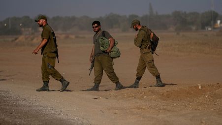 ثلاثة جنود إسرائيليين يسيرون في منطقة قريبة من الحدود مع غزة