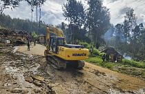 Los aldeanos utilizan maquinaria pesada para buscar entre un deslizamiento de tierra en Yambali, en las Tierras Altas de Papúa Nueva Guinea, el domingo 26 de mayo de 2024.