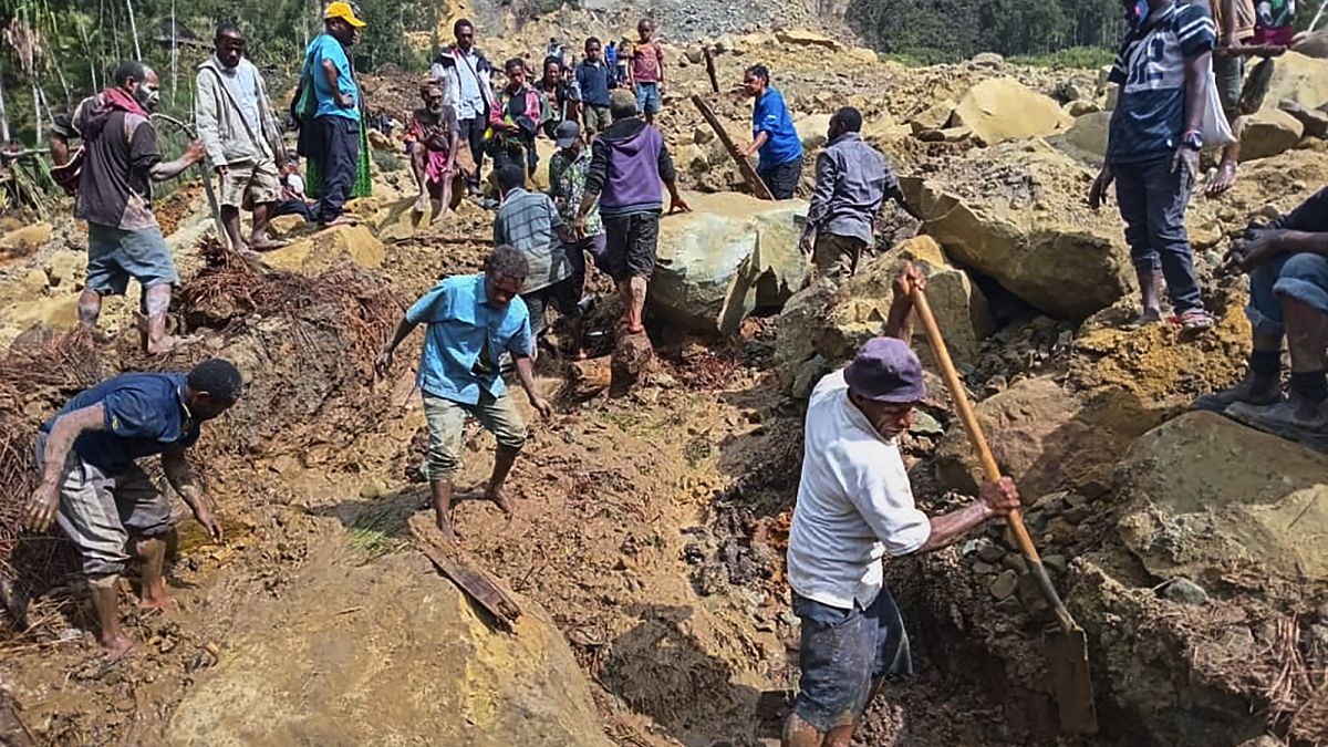 Köylüler 26 Mayıs 2024 Pazar günü Papua Yeni Gine'nin dağlık bölgesindeki Yambali'de meydana gelen toprak kaymasını araştırıyor.