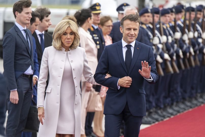 Presidente francês Emmanuel Macron e a mulher Brigitte chegam à secção militar do aeroporto BER, em Schoenefeld, perto de Berlim