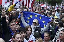 Demonstrators with Georgian national and EU flags rally during an opposition protest against foreign influence bill and to celebrate Independence Day, 