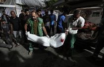 Médicos palestinos trasladan los cuerpos a la morgue del hospital Al Aqsa en Deir al Balah, en el centro de la Franja de Gaza, el 26 de mayo de 2024.